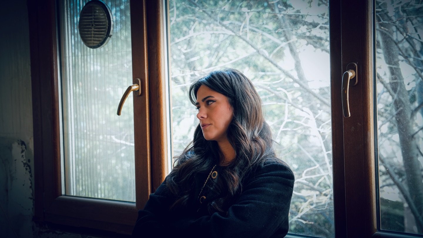 Merve Kıtırcı şantiyede, bir pencerenin önünde.